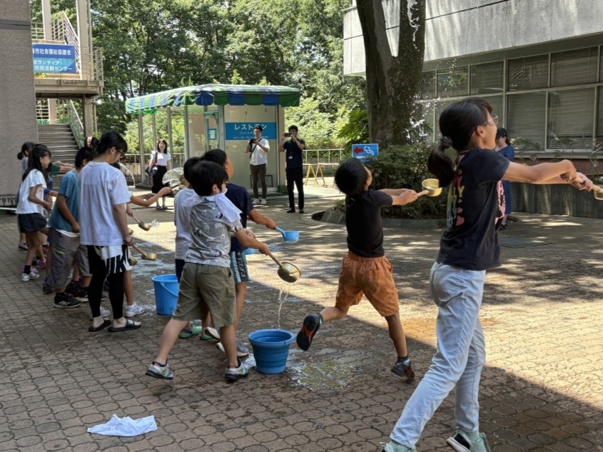 参加者の子どもたちが打ち水をしている様子の写真