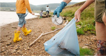 Several people are picking up trash on the beach.