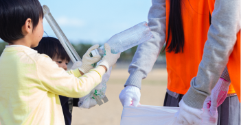Children and adults pick up trash together.