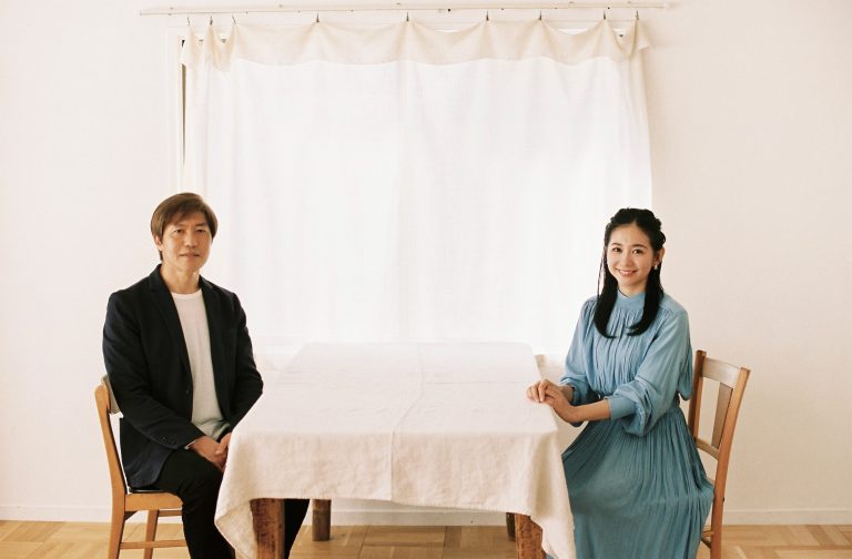 関根 麻里さんと江守 正多さんが同じテーブルに座って正面を見ている写真