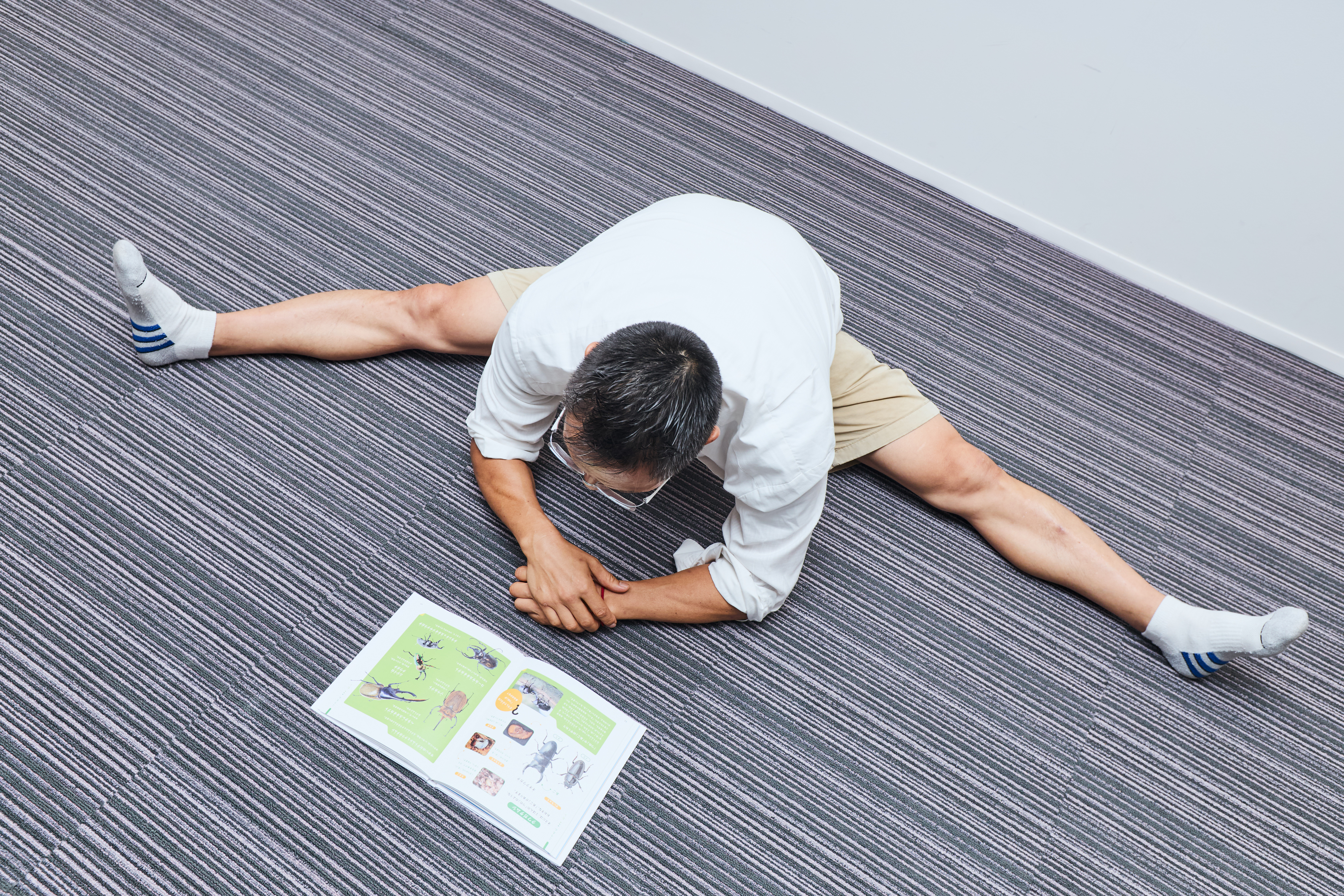 ストレッチをしながら本を読む谷本道哉先生