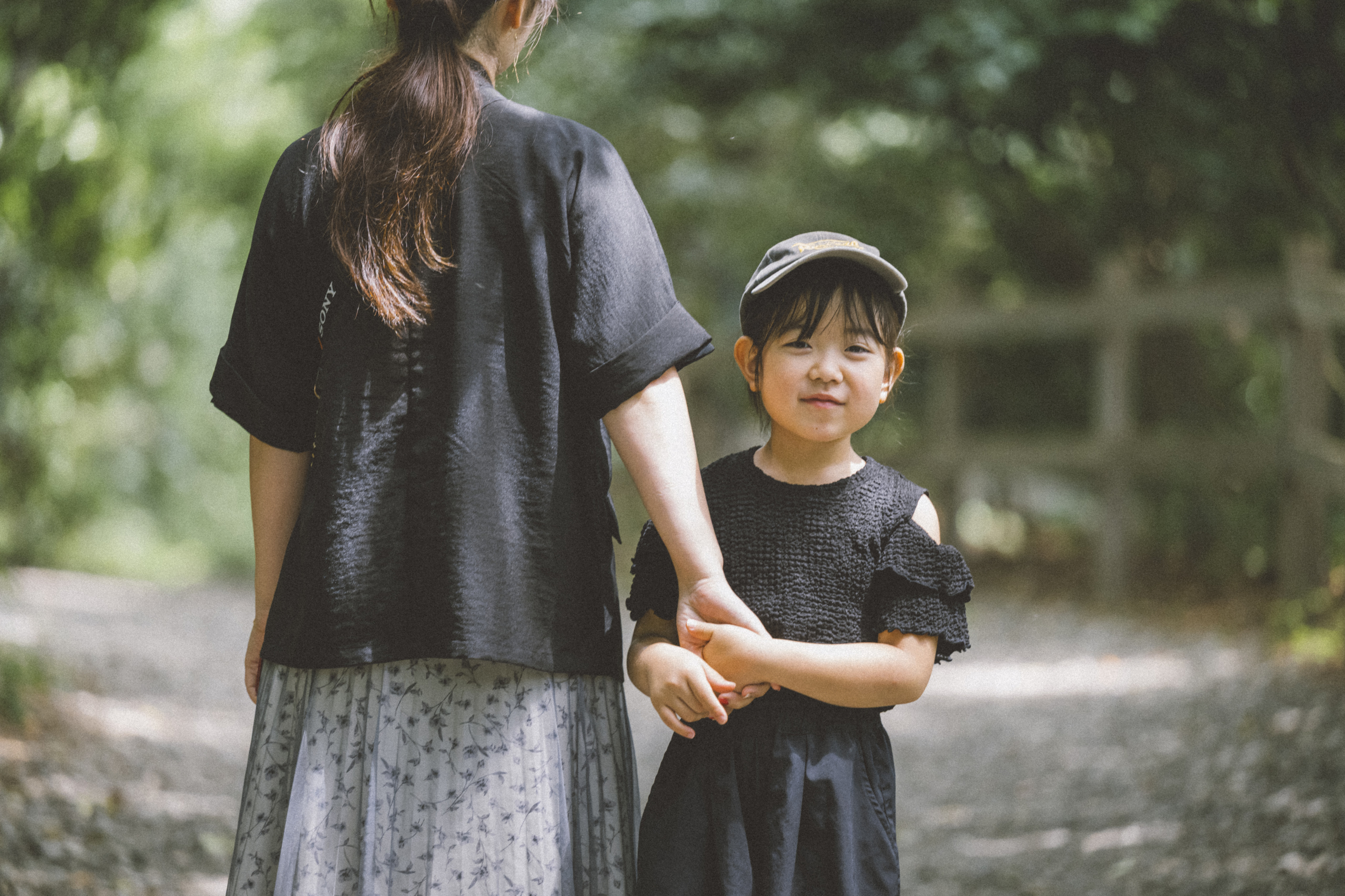 まさよさんとまおさんが手をつなぎながら、まおさんがこちらを向いている様子の写真
